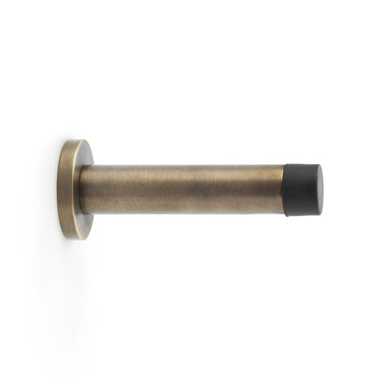 Antique Brass Cylinder Projection Door Stop on Rose by Alexander & Wilks, showcasing durable construction and concealed fixings
