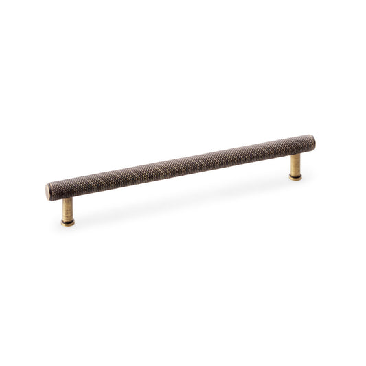 "Knurled T-bar Cupboard Pull Handle in Antique Brass by Alexander & Wilks, featuring solid brass construction and non-slip grip texture, perfect for home and commercial use"