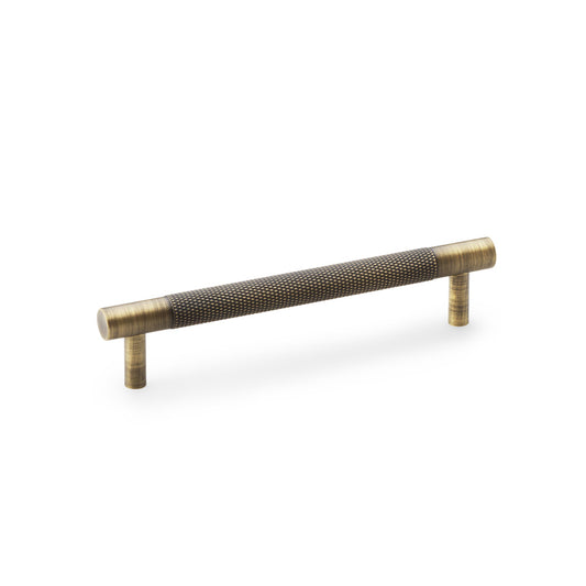 "Antique Brass Knurled T-Bar Cupboard Handle by Alexander & Wilks with diamond texture and classic finish, ideal for enhancing interior spaces"
