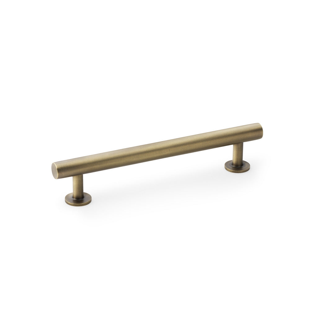 Antique brass T-Bar cabinet pull handle by Alexander & Wilks, 128mm centres, on wooden cabinet door.