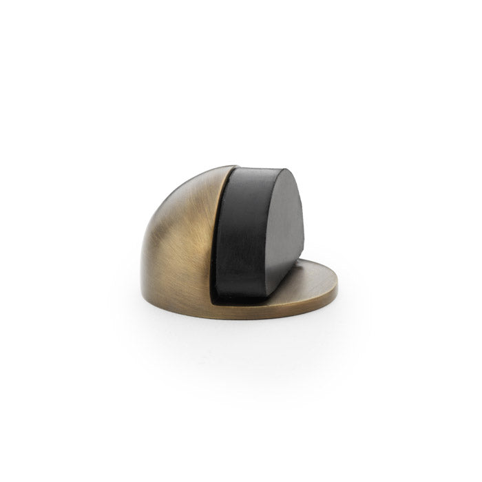 "Alexander and Wilks Shield Floor Mounted Door Stop in Antique Brass, traditional oval design with rubber stopper"